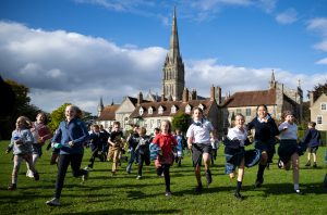 Group of young children running across the lawn